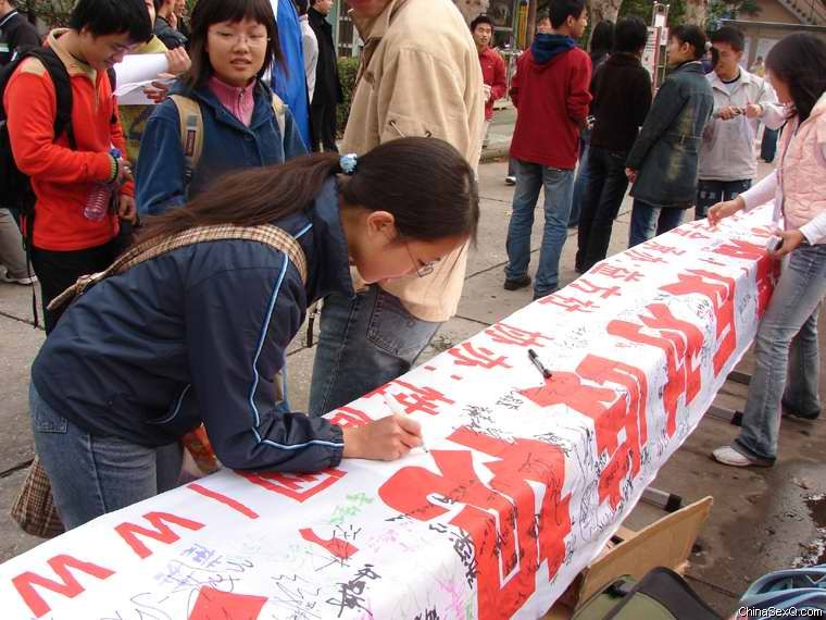 女同学大方的签上自己的名字,写上寄语