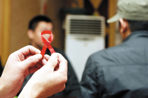 拍照时,小新要求,用关注艾滋病防治的标志红丝带挡住自己的脸