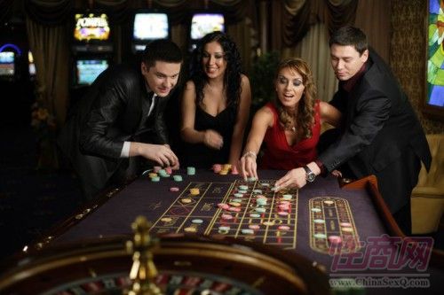 赌场年轻赌客和美女侍应赌客一起下注 赌场年轻赌客和美女侍应赌客一起下注
