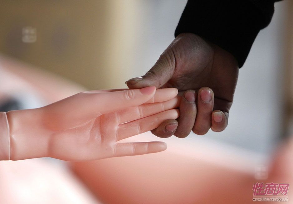 图为工人在检查充气娃娃的气密性。