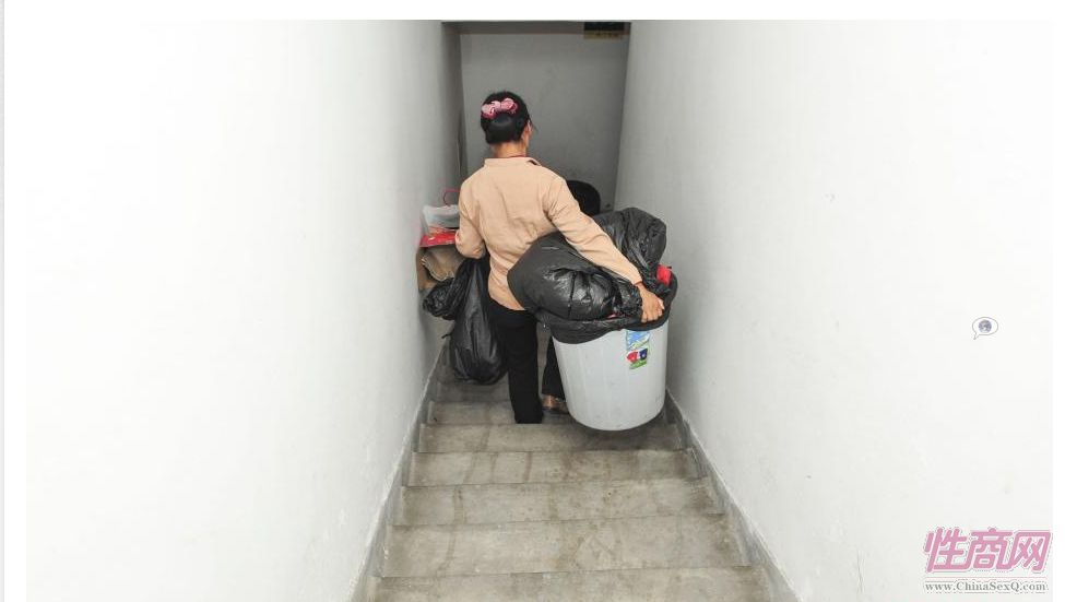 王书伟在楼梯间里的清理住户的生活垃圾,最重的时候一桶垃圾重达八十斤。她白天在一家物业公司上班,每天负责小区一栋32层住宅楼的清洁卫生,每个月能为她带来1650元的收入。